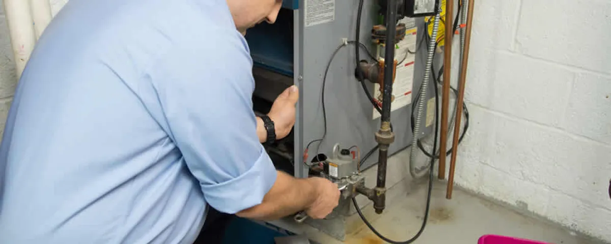 Furnace repair technician inspecting and servicing a home heating system in Marietta, GA