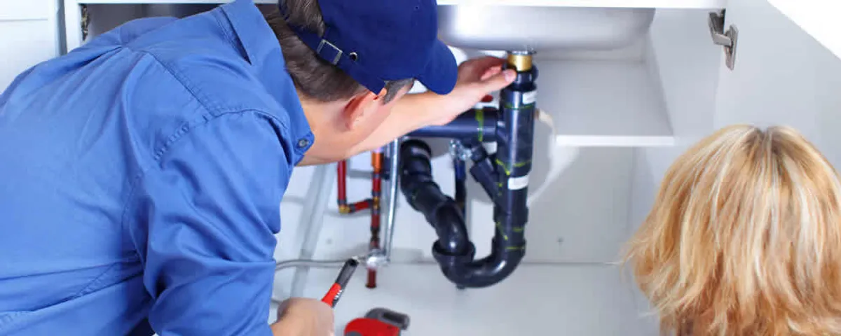 Plumber repairing under-sink drain pipes and fittings in Marietta, GA